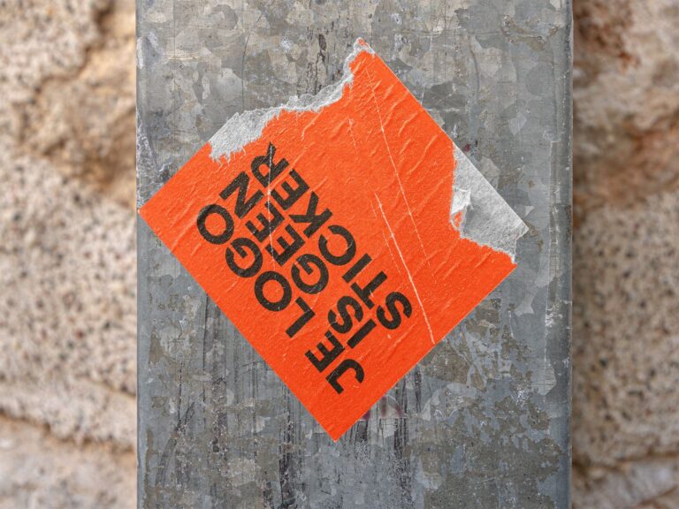 Versleten oranje sticker op metalen oppervlak